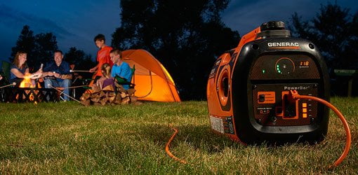 Camping familiar de noche con generador portátil.