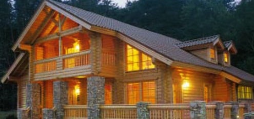 Hermosa casa de madera con luces encendidas por la noche